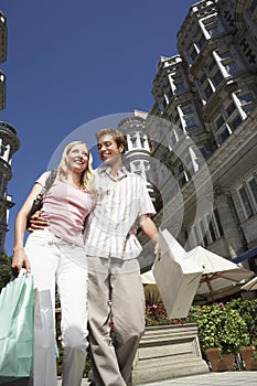 Couple On City Street With Shopping Bags