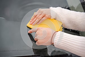 Couple cleaning car windshield with rag close up