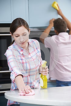 Couple Cleaning Kitchen Surfaces And Cupboards Together