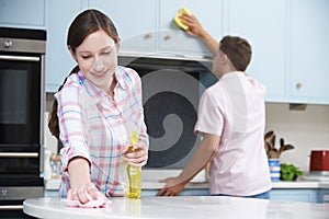 Couple Cleaning Kitchen Surfaces And Cupboards Together photo