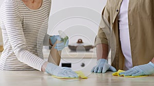 Couple Cleaning Kitchen Table Using Detergent Spray Wearing Gloves, Cropped