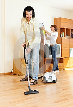 Couple cleaning with vacuum cleaner
