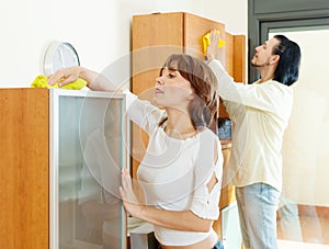 Couple cleaning wooden furiture