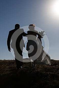 Couple climbing the hill with backlight, happiness
