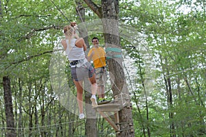 Couple climbing rope at adventure park