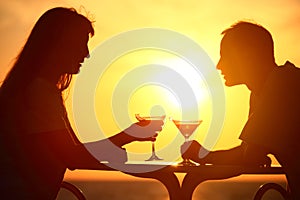 Couple clink glasses on sunset outside photo