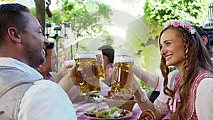 Couple clinking glasses with huge amounts of beer in Bavarian pub