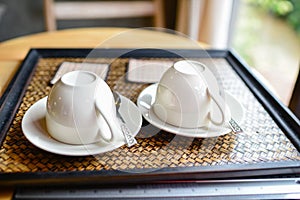 Couple coffee cups set on tray.