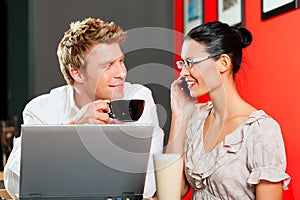 Couple in coffeeshop with laptop and mobile photo