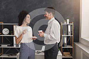 Couple of colleagues drinking coffee at office