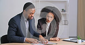 Couple of colleges afro american businessman and woman architect two designers analyzing plan looking at diagram