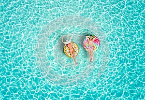 Couple on colorful floats over turquoise colored sea of the Maldives photo
