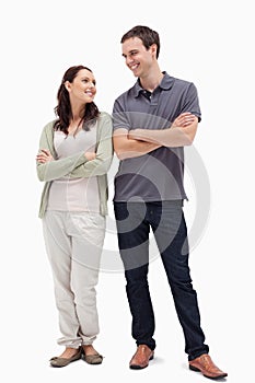 Couple with a complicit smile while crossing their arms