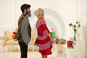 Couple concept. Couple in love celebrate spring. Couple of man and woman hide flowers behind their backs. Couple romance