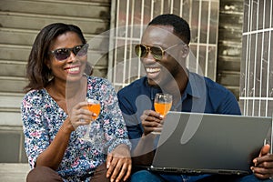 Couple connected to a computer and drinking fresh drink