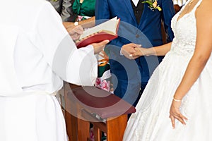 Couple consecrating marriage holding hands
