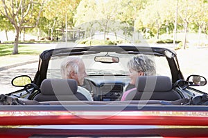 Couple in convertible car smiling