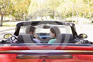 Couple in convertible car smiling