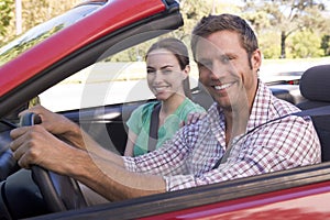 Couple in convertible car smiling