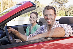 Couple in convertible car smiling