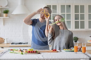 Couple is cooking on kitchen. Handsome man and attractive young woman are having fun together while making salad. Healthy