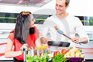 Couple cooking pasta in domestic kitchen