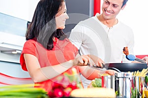 Couple cooking pasta in domestic kitchen