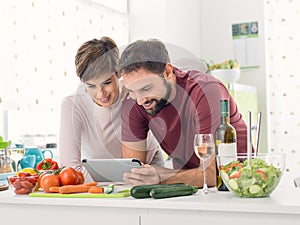 Couple cooking together and using a tablet