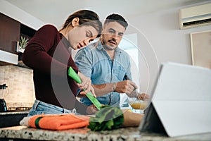 Couple Cooking Together Watching Tutorial For Recipe