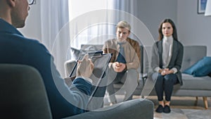 Couple on a Counseling Session with Psychotherapist. Foreground Focus on Back of the Therapist