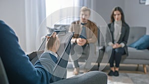 Couple on a Counseling Session with Psychotherapist. Foreground Focus on Back of the Therapist