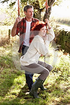 Couple in country on garden swing