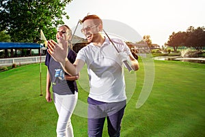 Couple at the course playing golf and looking happy - Image