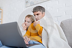 couple covered in blanket watching scary