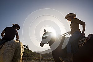 Couple of cowboy ride horses with sunflare