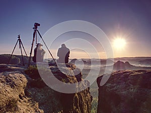 Couple of creative artists work and talk on exposed rock ledge