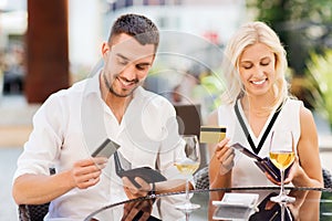 Couple with credit cards paying bill at restaurant