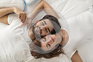 Couple cuddling in bed after waking up