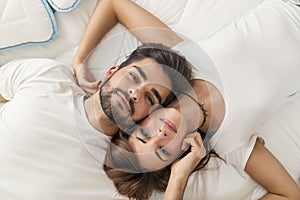 Couple cuddling in bed after waking up
