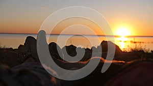 Couple cuddling with feet at sunset in tent