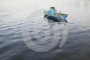 Couple Cuddling In Rowboat At Lake