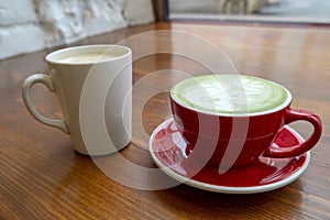 cups with coffee and matcha tea on a vintage wooden table in a coffee shop