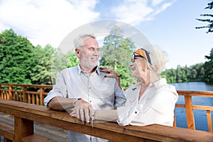 Couple of cute beaming pensioners wearing the same bright bracelets