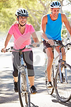 Couple Cycling On Suburban Street