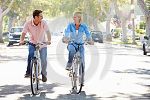 Couple Cycling On Suburban Street