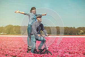 Couple cycling through tulip field