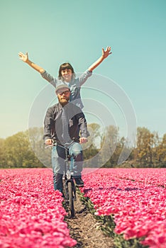 Couple cycling through tulip field