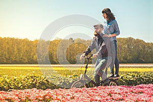 Couple cycling through tulip field