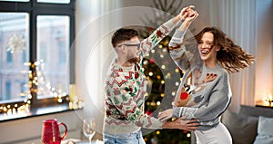 Couple dancing at christmas ugly sweaters party