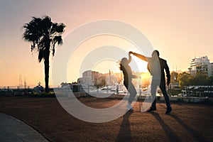 Couple dancing on city street. Spontaneous playful moment with motion. Guy and girl having fun and dating. Stylish trendy people.